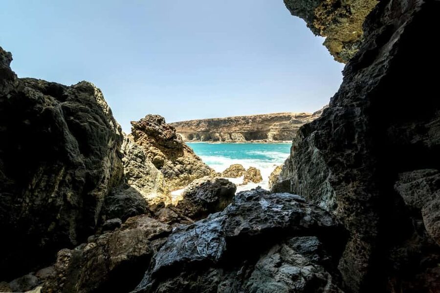 Fuerteventura farm, caves and rural villages tour with lunch - Ajuy black-sand beach and sea caves: chalk cliffs, real coastline, short window